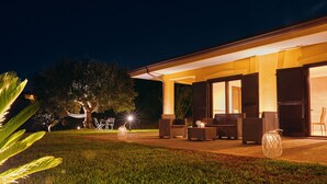 A well-lit outdoor patio area with seating and a hammock. - Cilentia B&B (Agropoli)