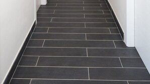 A hallway with dark tiled flooring, white walls, and a door at the end. - Cilentia B&B (Agropoli)