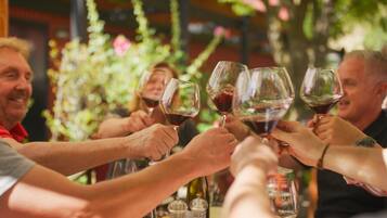 Um grupo de pessoas brindando com taças de vinho em uma mesa.