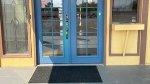 A building with a blue double door, a small window above the door, and a yellow wall. - Gila Bend Lodge (Gila Bend)