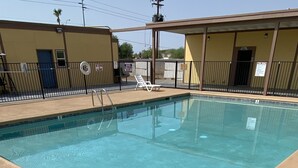 A rectangular pool with a clear blue water surface, surrounded by a concrete deck. - Gila Bend Lodge (Gila Bend)
