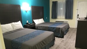 A hotel room with two beds, a desk, a chair, a phone, and a window with curtains. - Gila Bend Lodge (Gila Bend)