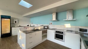A modern kitchen with a built-in dishwasher, a microwave, and a stainless steel range hood. - Pacific Park Christian Holiday Camp (Tauranga)