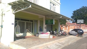 A building with a green awning, a sign with the letter 'W', and a basketball hoop outside.