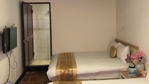 A hotel room with two beds, a shower, a TV, and a small table with flowers. - Wu Feng Homestay (Jinning)