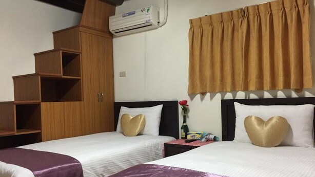 A hotel room with two beds, a wardrobe, a nightstand, and a window with curtains. - Wu Feng Homestay (Jinning)