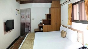 A bedroom with a bed, a TV, a wardrobe, a sink, and a window with curtains. - Wu Feng Homestay (Jinning)