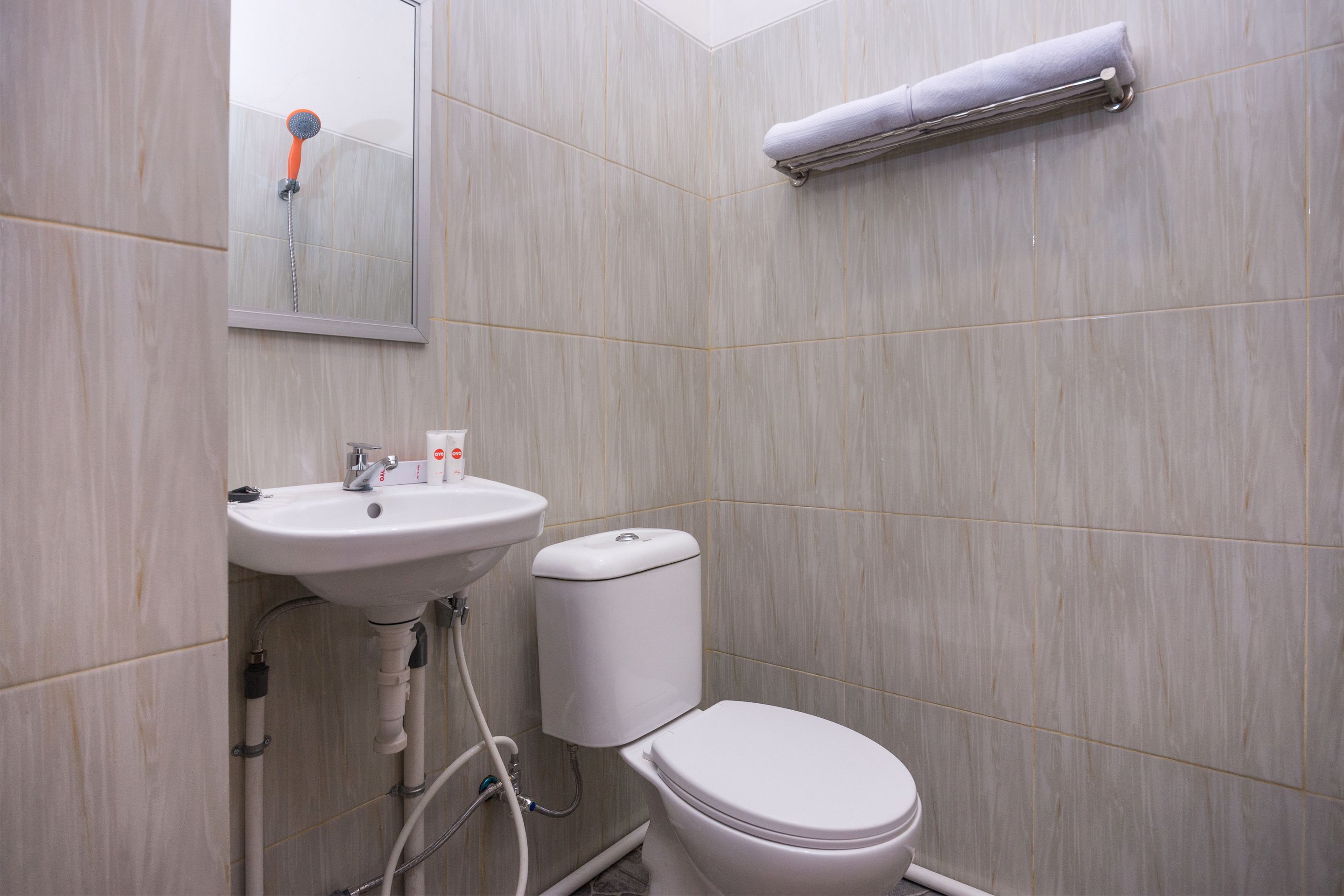 A bathroom with a white sink, toilet, and a towel rack.