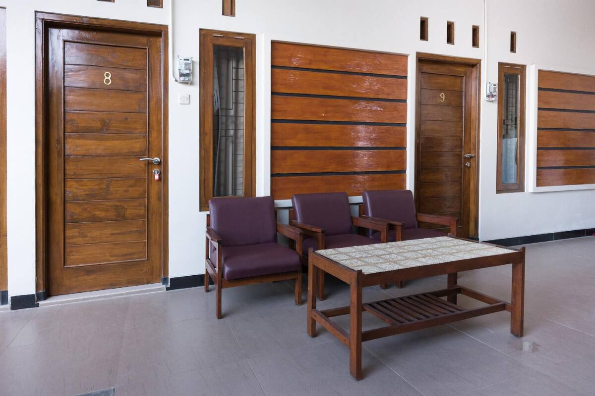 A lobby with wooden doors numbered 8 and 9, purple chairs, and a wooden table with a patterned tablecloth.