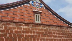 A brick building with a decorative roof and a small window. - Rong Shu Xia B&B (Jinning)