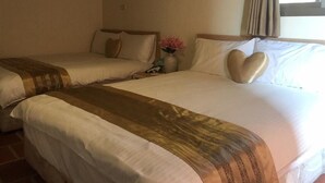 A hotel room with two beds, each with a heart-shaped pillow, a nightstand with a vase of flowers, and a window with curtains. - Rong Shu Xia B&B (Jinning)