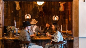 A rustic bar setting with wooden walls, mounted animal heads, and vintage decor. - Cuyama Buckhorn (New Cuyama)