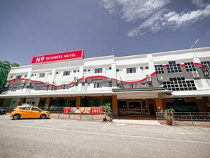 A multi-story building with a prominent red sign indicating it is a business hotel. - N9 Business Hotel (Nilai)