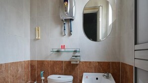 Un baño con inodoro, lavamanos y espejo.