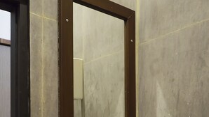 Een badkamer met een witte wastafel, een spiegel en een deur.
