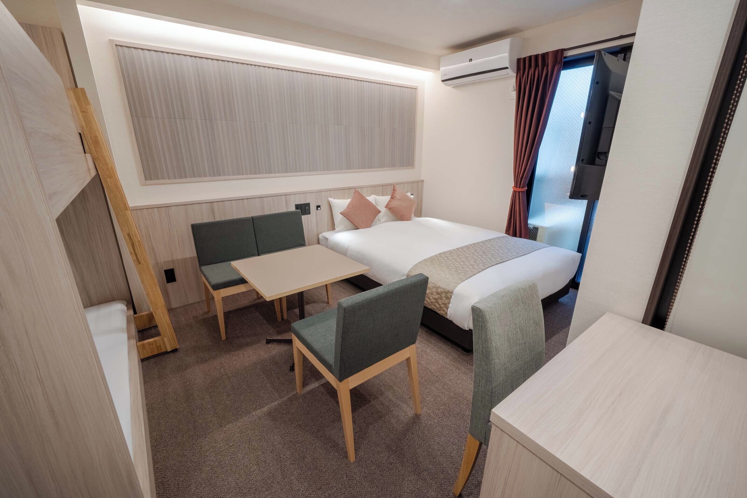 A compact hotel room with a bed, a small desk, and a chair.