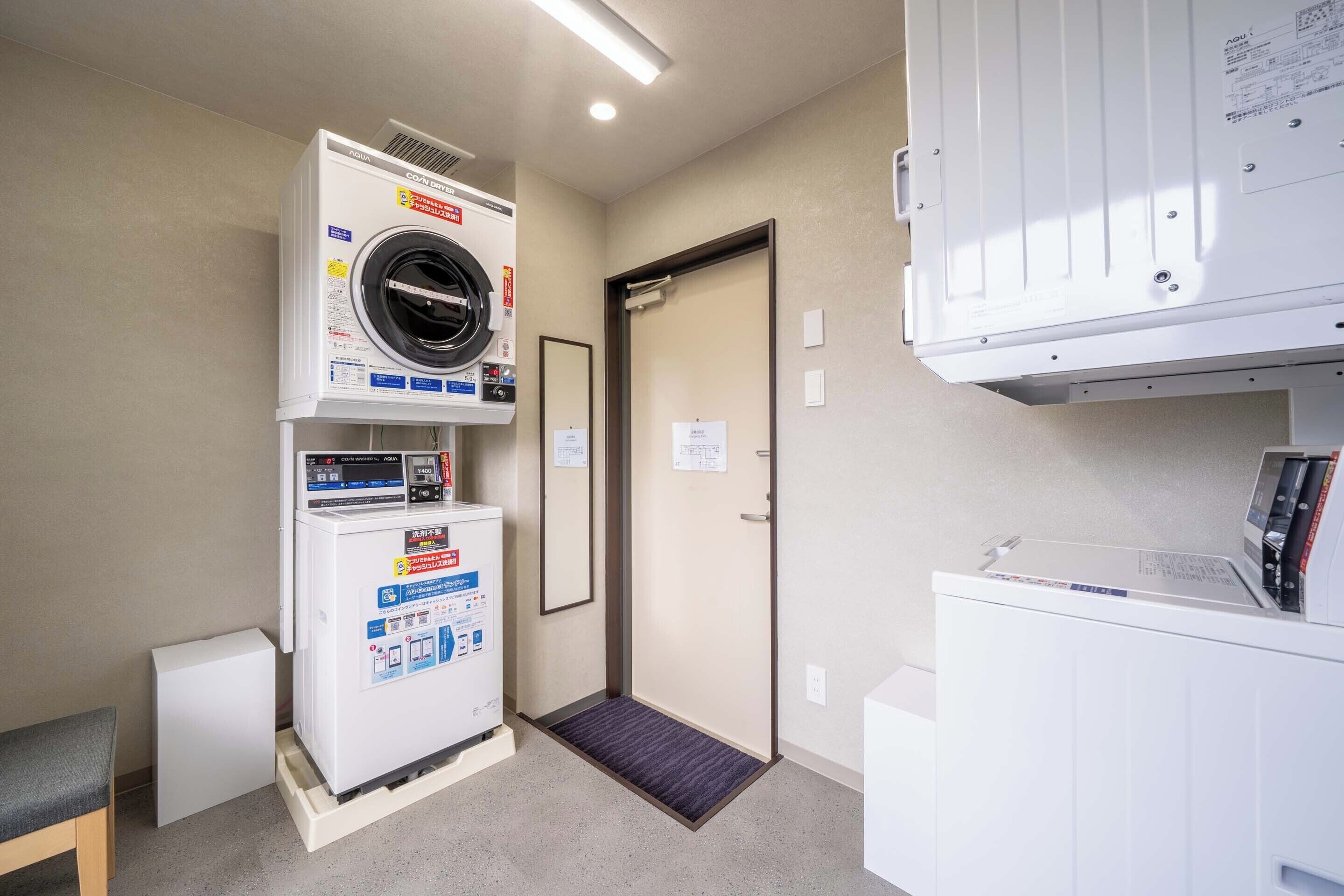 A laundry room with a washing machine, dryer, and a small bench.