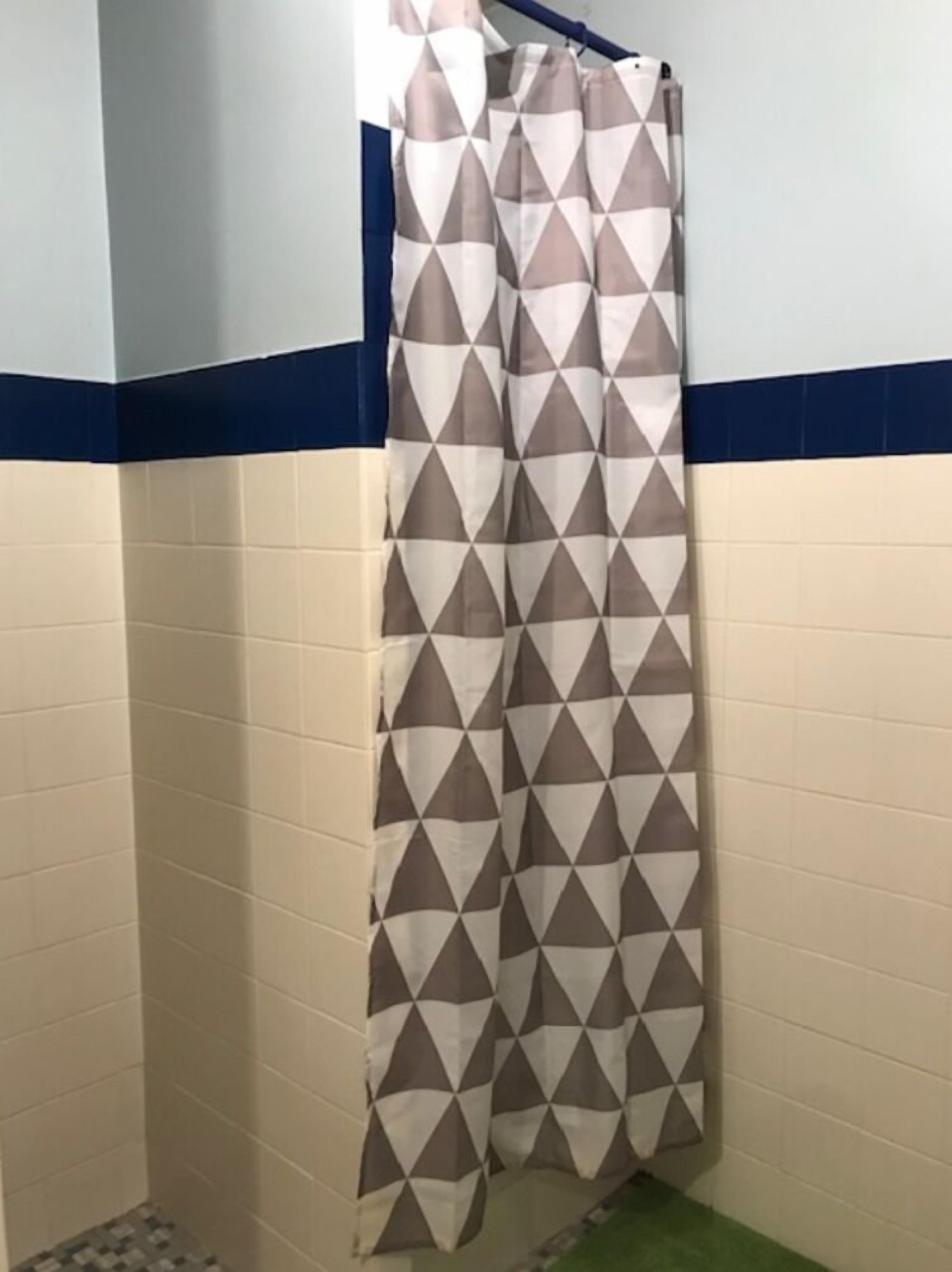 Un bagno con tenda doccia decorata con un motivo geometrico.