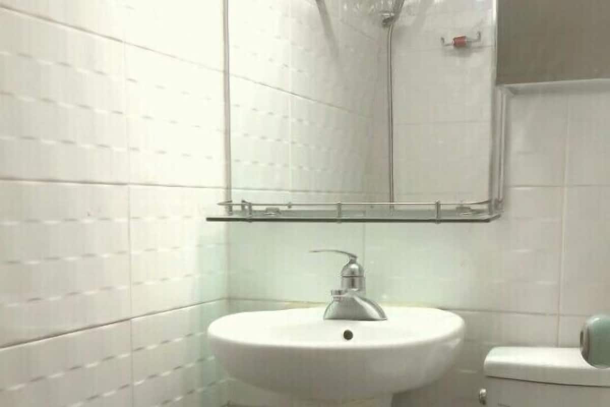 Un baño con lavamanos blanco, inodoro y ducha con cabina de vidrio.