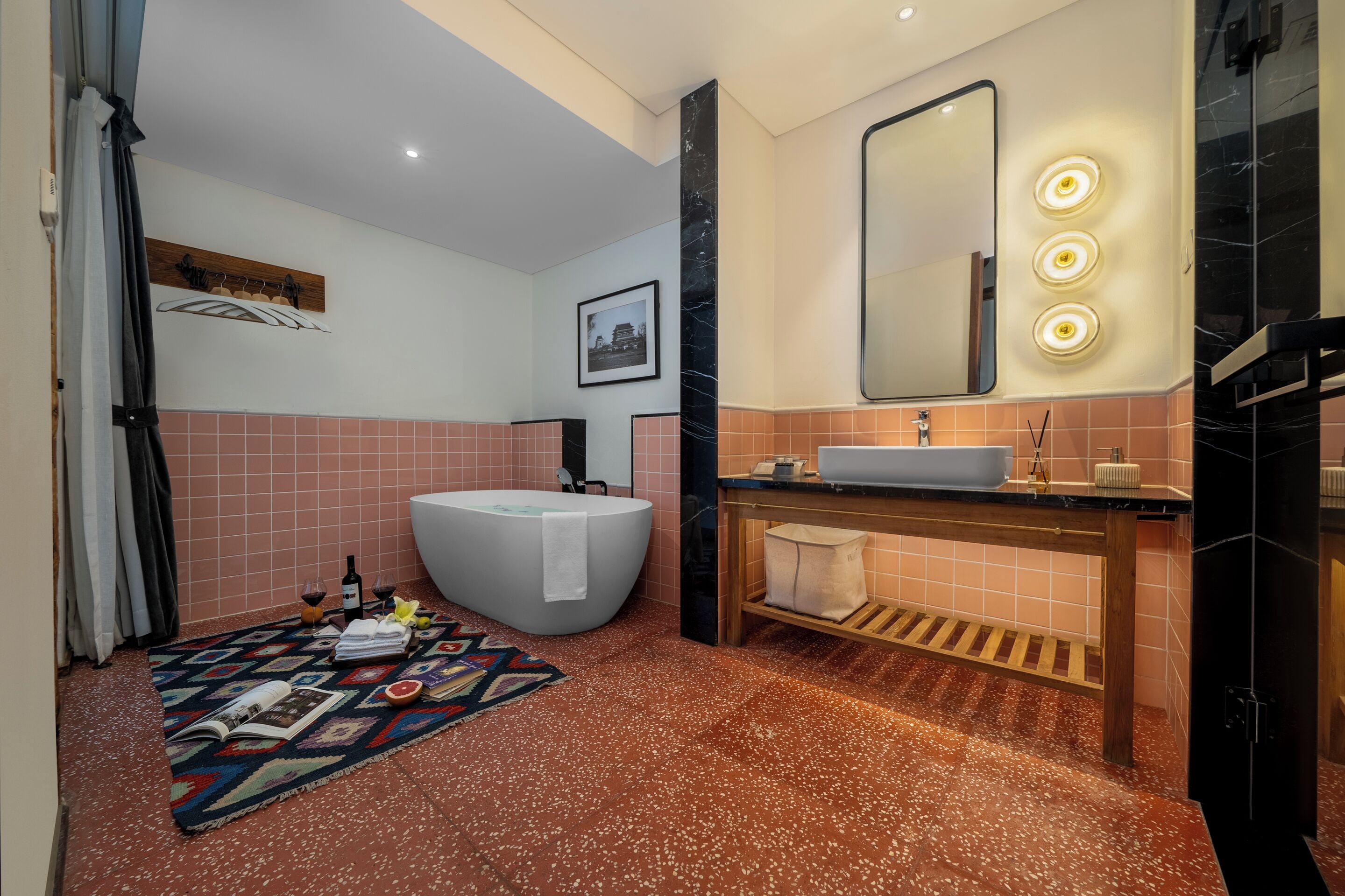 A modern bathroom with a freestanding bathtub, a vanity with a sink, and a large mirror with lights.