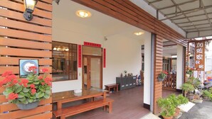 Fachada de madeira com um banco e plantas em vasos.