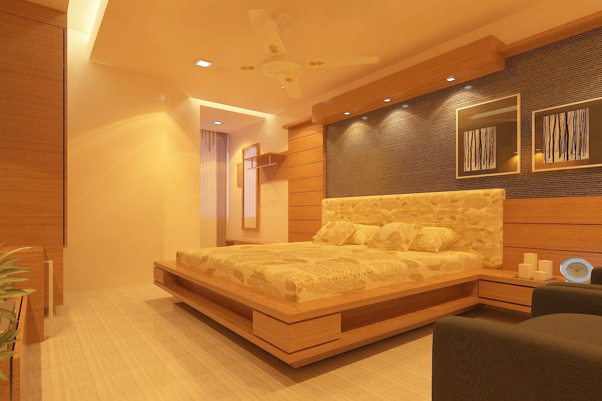 Un dormitorio moderno con estructura de cama de madera, mesita de noche integrada y ventilador de techo.