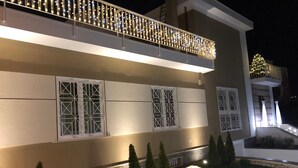 A modern building with a balcony, large windows, and decorative spherical lights in the garden. - B&B Lapillus (Pompei)