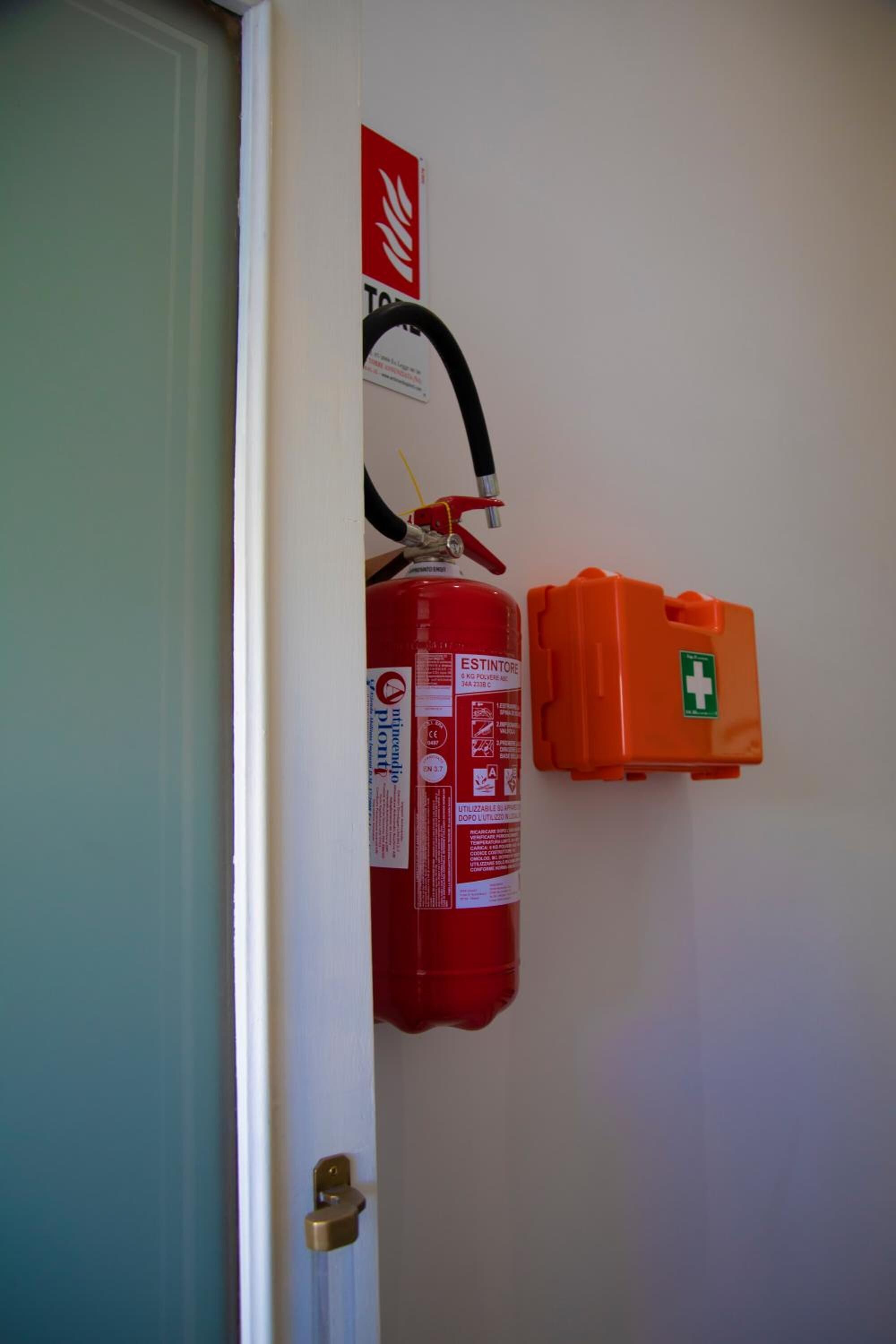A fire extinguisher mounted on a wall next to a door.