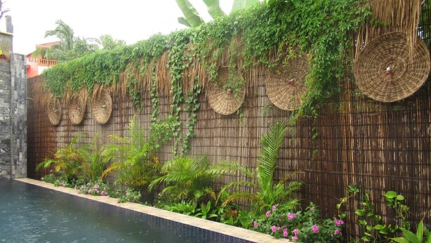 A swimming pool with a bamboo wall and woven baskets. - 333 HOSTEL, Siem Reap (Siem Reap)