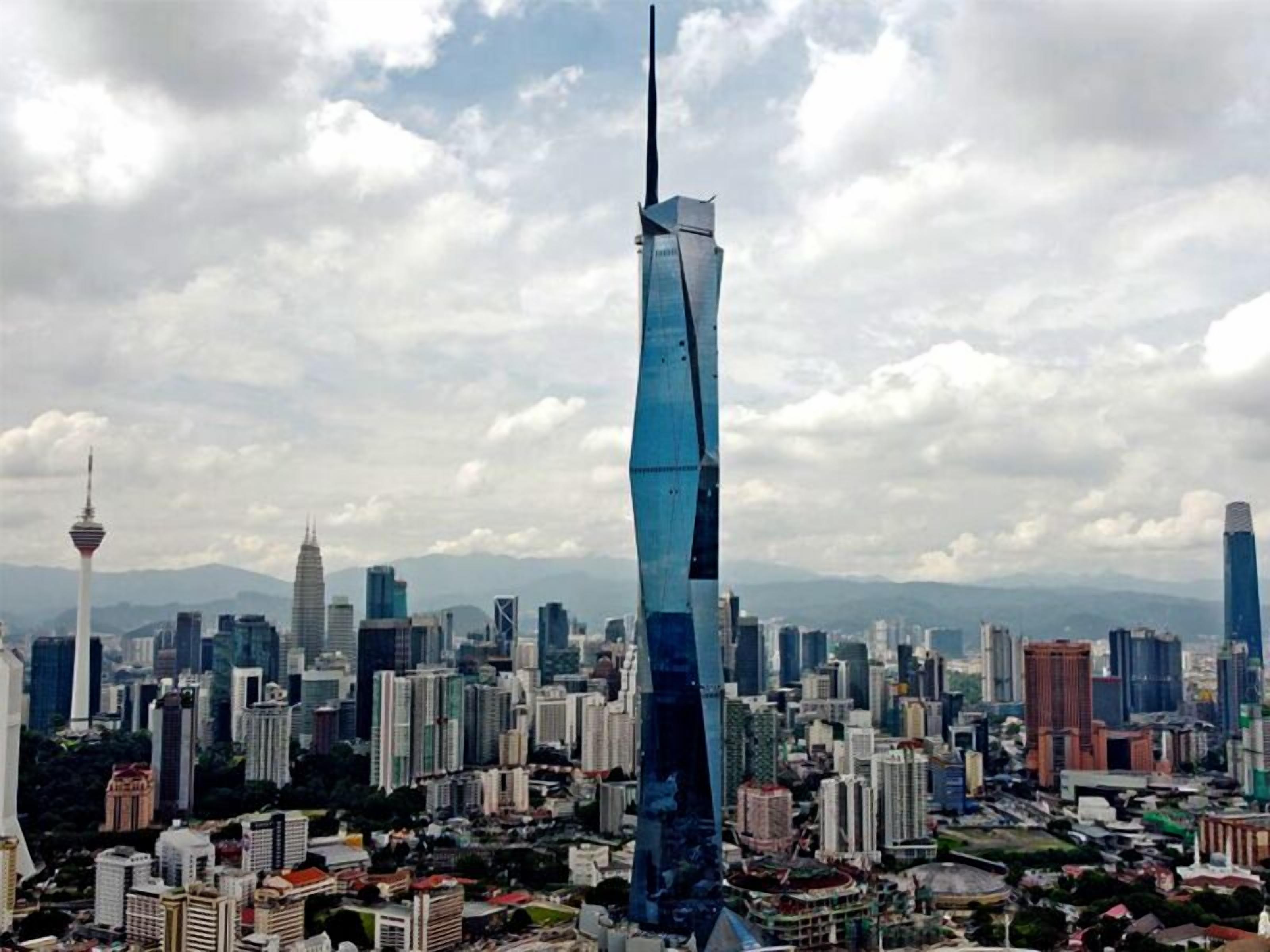 A cityscape with a prominent skyscraper featuring a unique twisted design, surrounded by various other high-rise buildings and a clear sky.