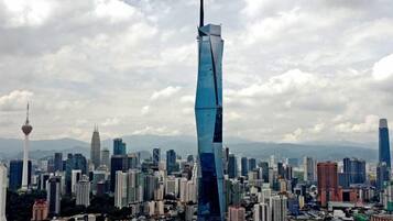 A cityscape with a prominent skyscraper featuring a unique twisted design, surrounded by various other high-rise buildings and a clear sky.