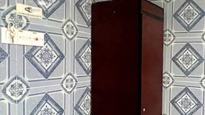 A room with patterned wallpaper, a dark-colored wardrobe, and a black floor mat. - Ark Batu Caves Hotel (Batu Caves)