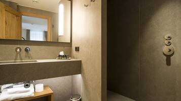 Une salle de bain moderne avec un grand miroir, un lavabo avec une serviette et des toilettes.