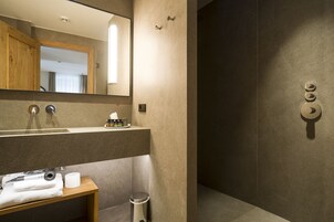 Une salle de bain moderne avec un grand miroir, un lavabo avec une serviette et des toilettes.