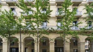A multi-story building with a classical architectural style, featuring arched doorways and balconies. - Hotel Arbaso (San Sebastián)