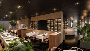 A modern restaurant with wooden paneling, marble flooring, and a bar area with wine bottles. - Hotel Arbaso (San Sebastián)