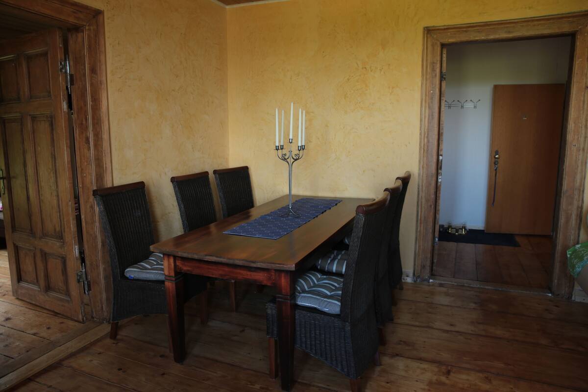 A dining area with a wooden table, four chairs, and a candelabra.