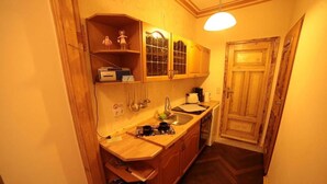 Una cocina compacta con armarios de madera, horno empotrado y pileta.