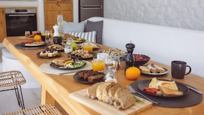 Ein Frühstückstisch mit verschiedenen Speisen, darunter Toast, Obst und Getränke.
