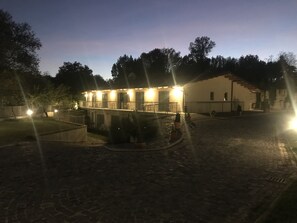 A building with a courtyard, outdoor seating, and a paved area. - Oasi del Vetoio (L'Aquila)