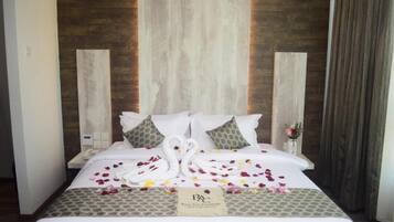Una habitación de hotel con cama, almohadas, un cartel y una pared con paneles de madera verticales.