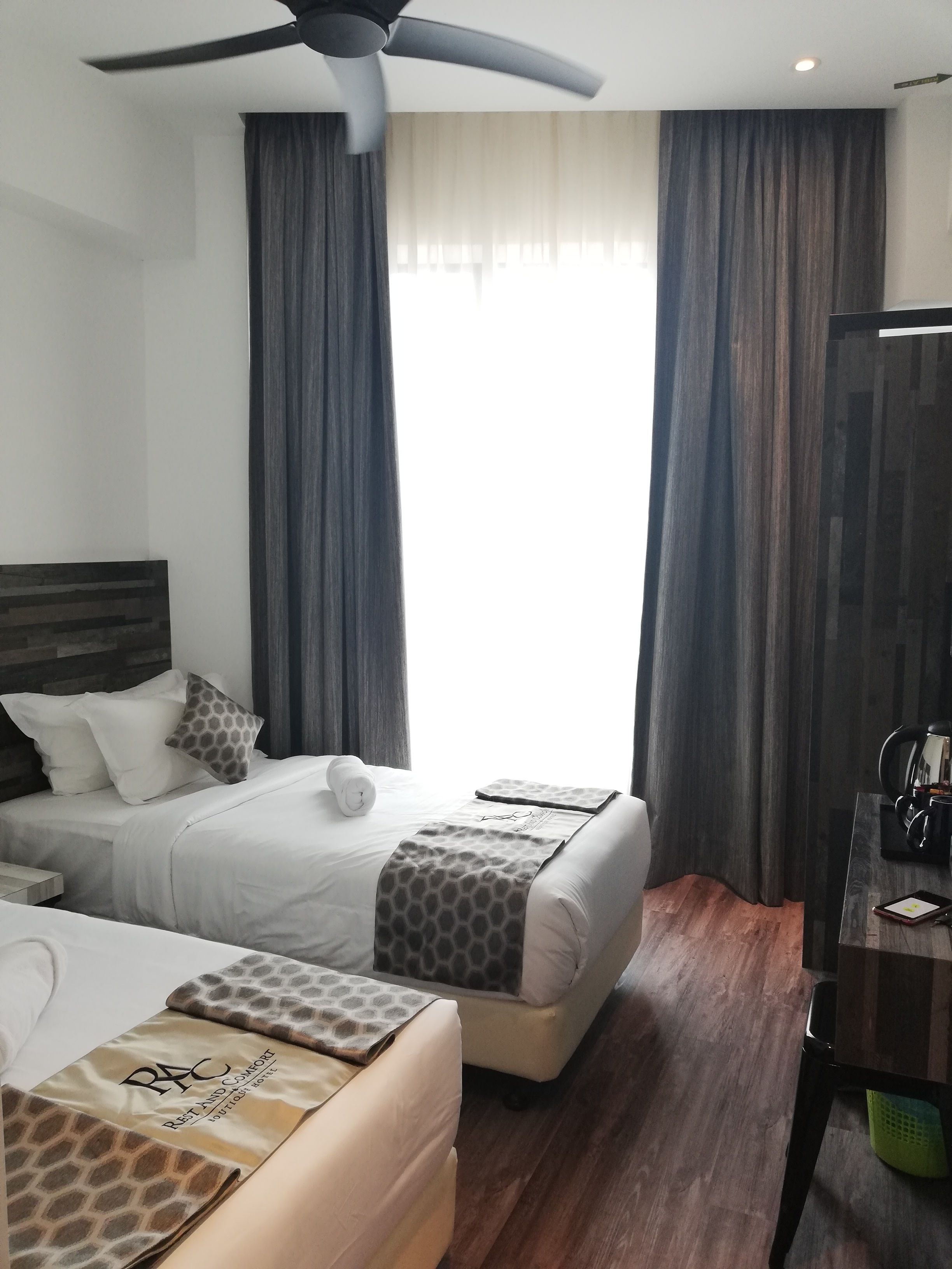 Una habitación de hotel con cama, escritorio y ventilador de techo.