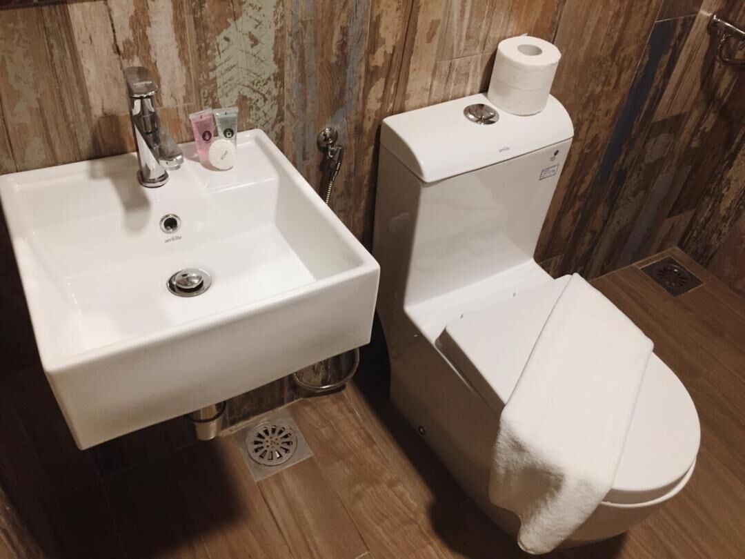 Ein Badezimmer mit Waschbecken, Toilette und Holzboden.