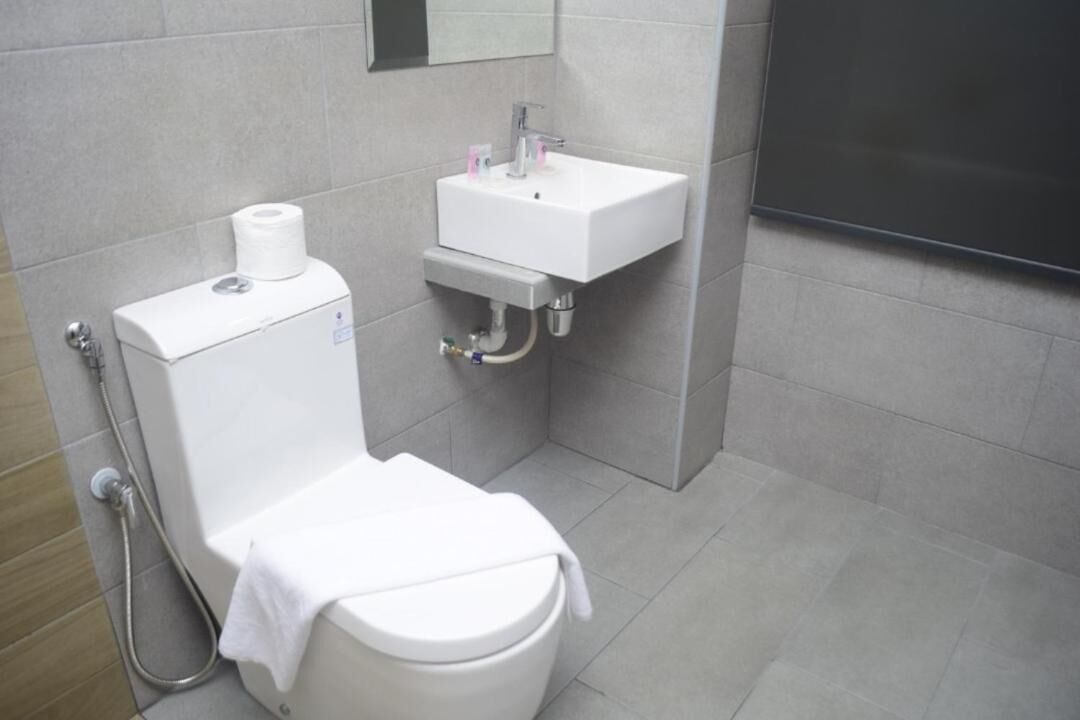 A modern bathroom with a toilet, sink, and shower.