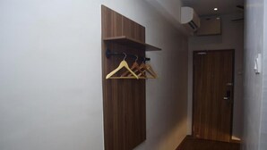 A hallway with a wooden wardrobe and a coat rack with hangers. - Rest and Comfort Boutique Hotel (Kuala Terengganu)