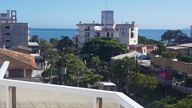 A terrace with a view of the sea and surrounding buildings. - Residencial Ilhas Gregas (Florianópolis)