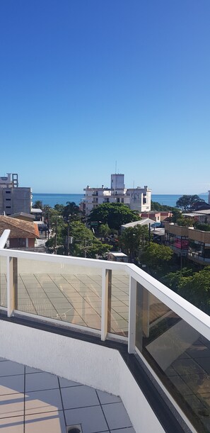 Eine Terrasse mit Blick auf das Meer und die umliegenden Gebäude.