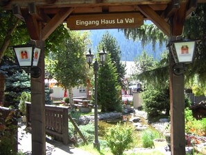 Una pérgola de madera con un letrero que dice "Eingang Haus La Val".