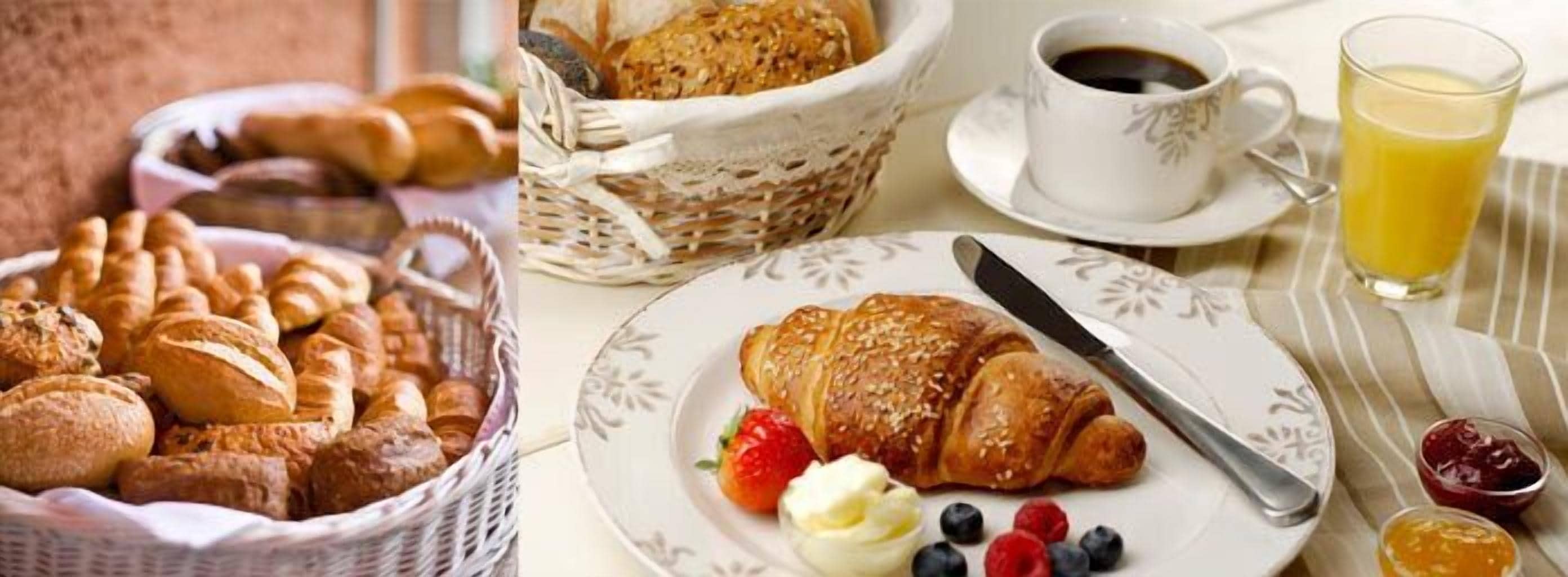 Une table dressée pour le petit-déjeuner avec du pain, des croissants, des fraises, des myrtilles et une tasse de café.