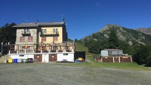 A two-story building with a balcony and a garage. - Osteria Gaute La Nata (Viu)